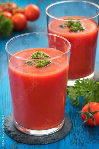 Glasses of fresh Tomato juice on a wooden table.