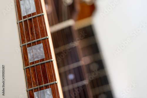 Photography Close up of a Rosewood pearl inlaid  fretboard with six strings on an Electric G