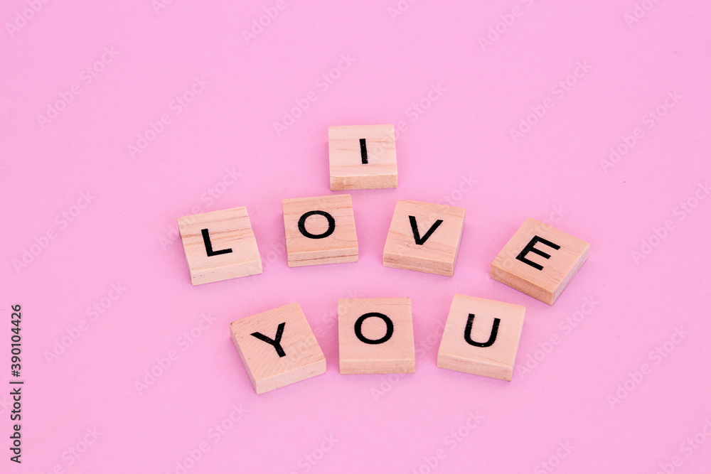 Lettering I love you in wooden letters on a pink background. Lettering I love you in wooden letters on a pink background.