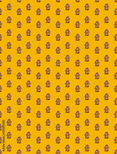 Orange abstract background. Cute seamless pattern. Brown gingerbread man ornament wallpaper for boys girls. Decorative design poster isolated on bright yellow.