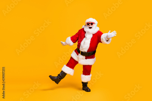 Full length photo of crazy santa claus with grey beard listen jolly holly music headset dance x-mas christmas party wear sunglass cap isolated bright shine color background © deagreez