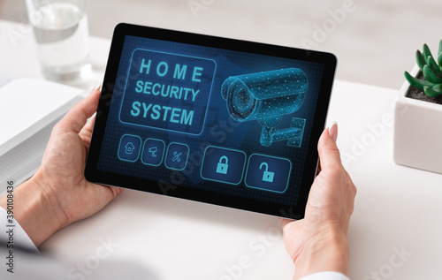 Woman using digital tablet with home security application