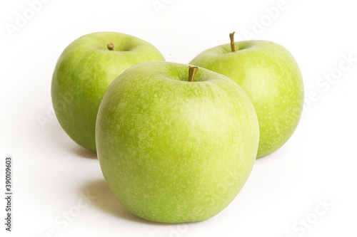 three fresh green apples on a white background