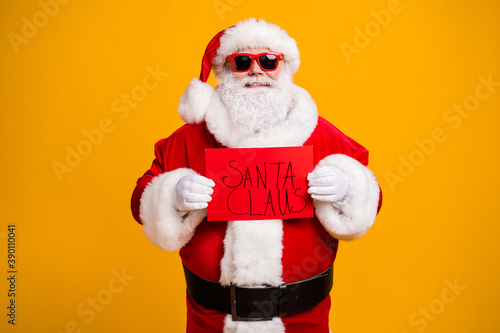 Portrait of his he nice attractive cheerful cheery confident bad Santa holding in hands red board wanted search seeking occupation isolated bright vivid shine vibrant yellow color background