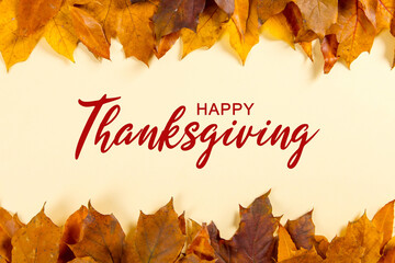 Thanksgiving greetings. Dry yellow leaves and frame on yellow background, top view. Kaligraphic capital inscription.