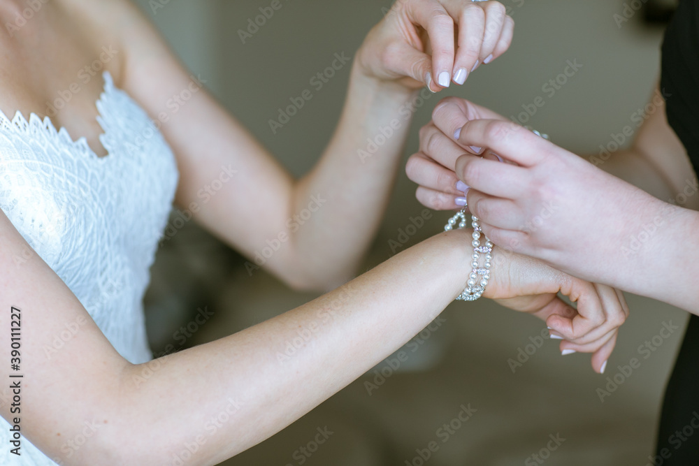 bride putting on jewelry for wedding day