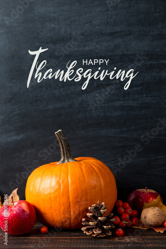 Thanksgiving greetings. Pumpkin, leaves, apples on a chalkboard background, top view. Kaligraphic capital inscription.