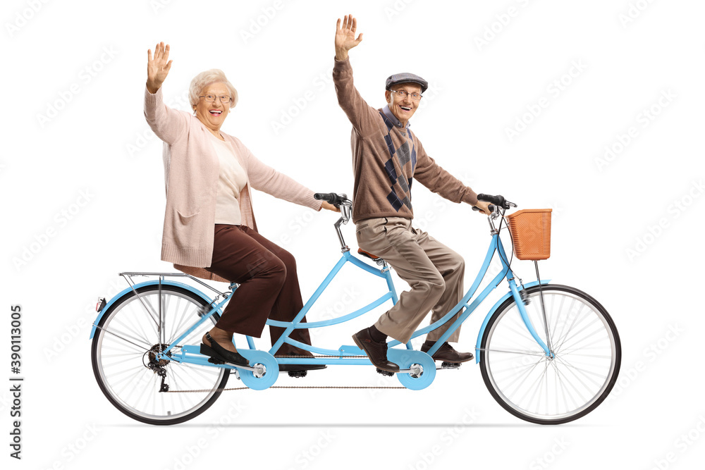 Elderly couple riding a blue tandem bicycle and waving Elderly couple riding a blue tandem bicycle and waving