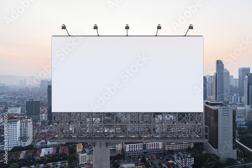 Photography Blank white road billboard with Kuala Lumpur cityscape background at sunset