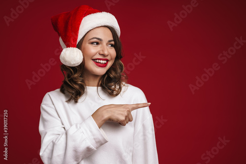 Happy cheery young woman in christmas santa hat