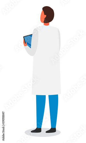 Laboratory assistant, scientist, engineer, researcher, doctor wearing white gown holding digital tablet in hands. Man standing back isolated at white background. Medical staff, using modern technology
