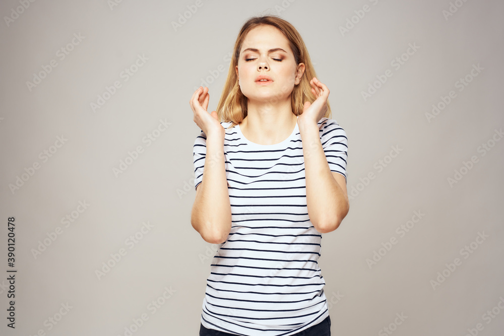 Emotional blonde woman in striped t-shirt lifestyle facial expression close-up Emotional blonde woman in striped t-shirt lifestyle facial expression close-up