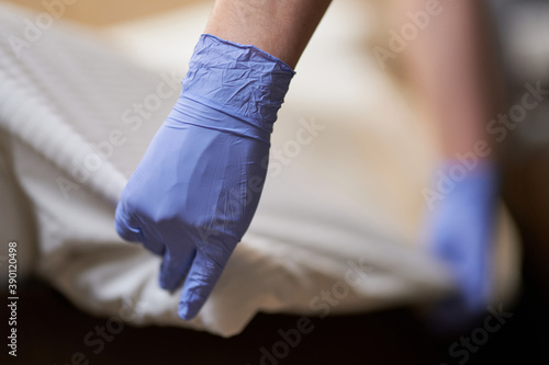 Housemaid doing regular bed linen change in room