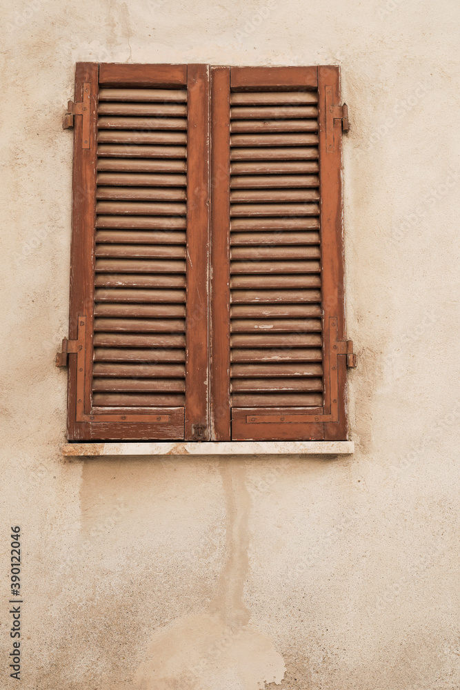old window with wodden shutters, wall weathered and cracked, space for text and vertical format