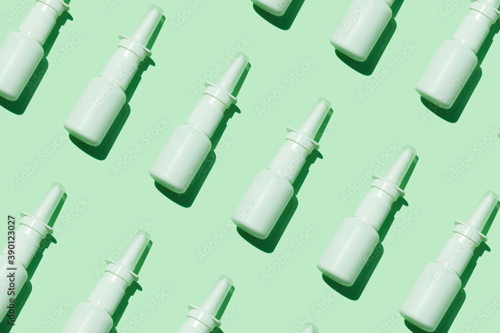 White medical nasal spray bottle on aqua mint background pattern flat lay with harsh shadow minimalism style. Allergy runny nose remedy, cold flu, viral diseases. COVID-19 pandemic, rhinitis therapy.
