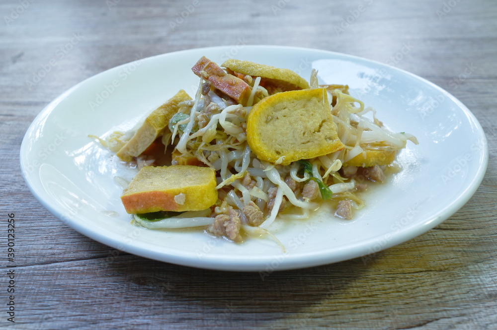 fried bean sprout with slice yellow tofu and chop pork in plate on table