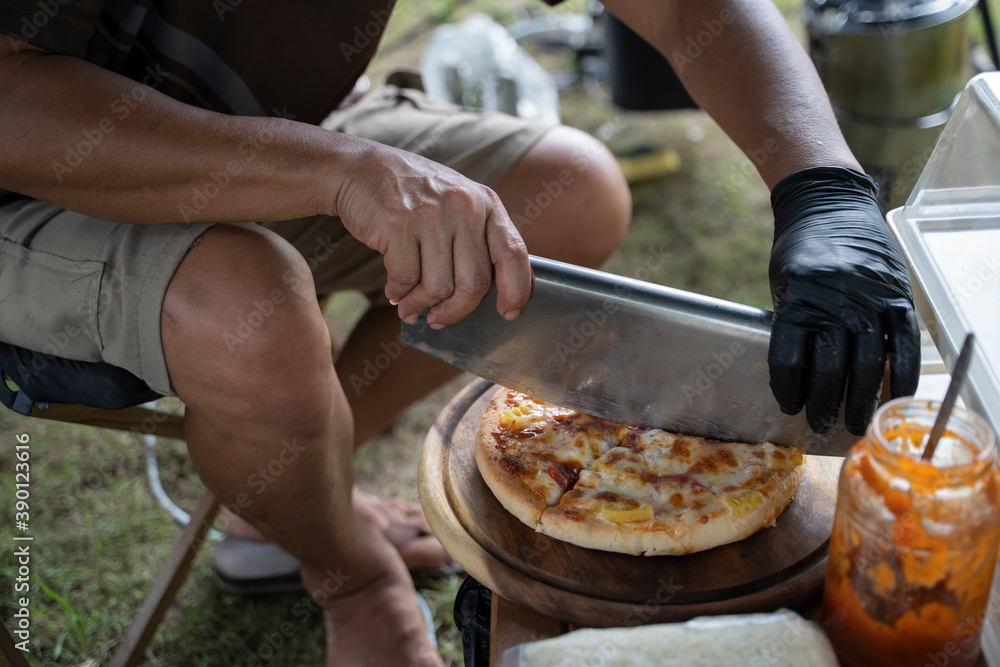 Man slicing pizzeria while it's still hot.