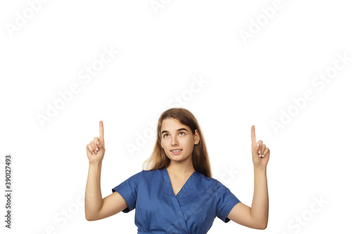Young beautiful woman doctor in a blue surgical gown shows fingers over head isolated on white background. Copspace