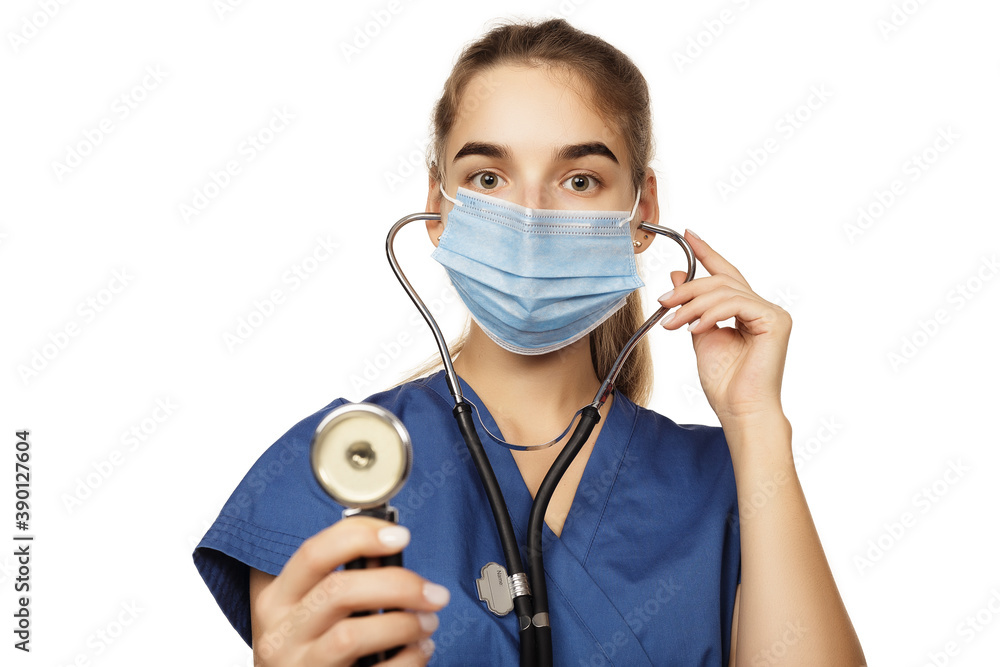 Young beautiful woman doctor in blue surgical gown with stethoscope isolated on white background. Copspace Young beautiful woman doctor in blue surgical gown with stethoscope isolated on white background. Copspace