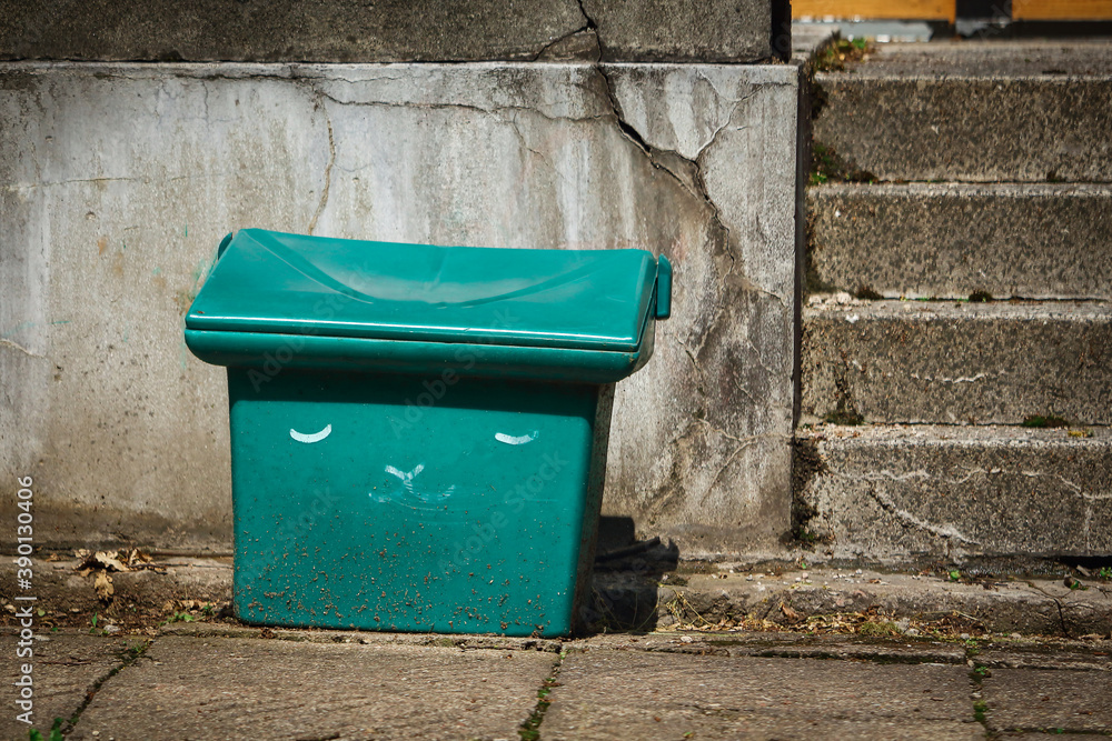 Green plastic sand box standing on pavement beside old crumbly wall and concrete stairs Green plastic sand box standing on pavement beside old crumbly wall and concrete stairs