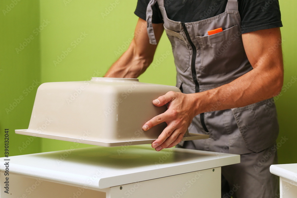 hands of worker installs kitchen sink hands of worker installs kitchen sink