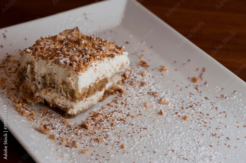 Tiramisu Dessert. Classic Italian dessert. Lady fingers soaked in syrup, espresso and layered with cream, nuts and powdered sugar.