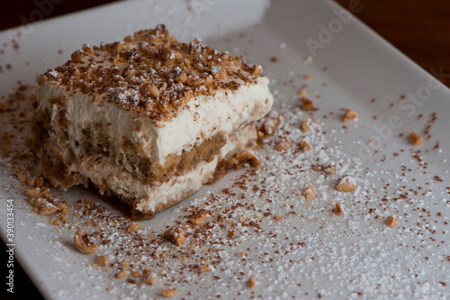 Tiramisu Dessert. Classic Italian dessert. Lady fingers soaked in syrup, espresso and layered with cream, nuts and powdered sugar.