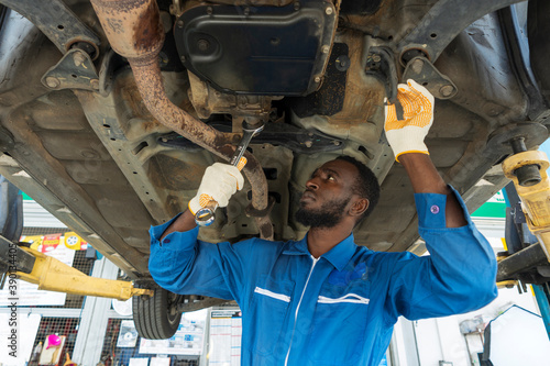 Auto mechanic working in garage, car repair services	