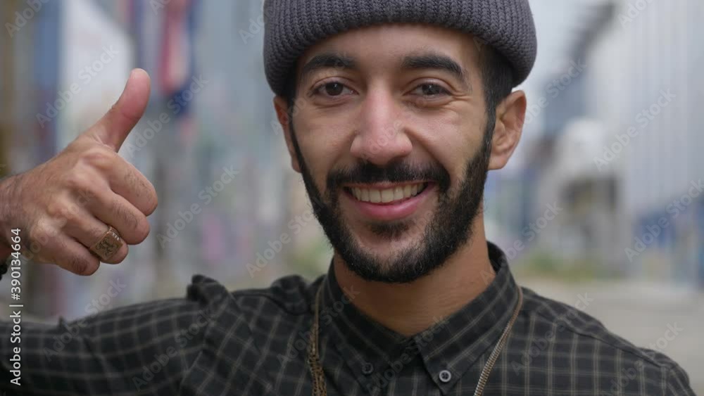 portrait of a handsome young muslim man smiling, showing a thumbs up in the street, close up portrait portrait of a handsome young muslim man smiling, showing a thumbs up in the street, close up portrait