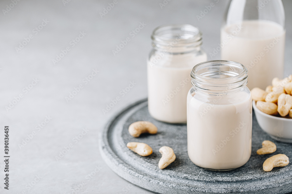 Cashew Nut Milk in glass on gray stone background Cashew Nut Milk in glass on gray stone background