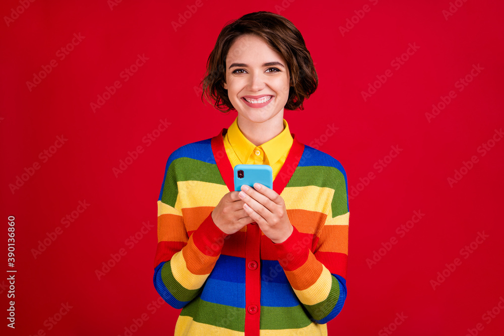 Photo of attractive pretty lesbian lady hold telephone hands reading girlfriend sms nice feelings overjoyed toothy smile wear stripes jumper cardigan isolated red color background Photo of attractive pretty lesbian lady hold telephone hands reading girlfriend sms nice feelings overjoyed toothy smile wear stripes jumper cardigan isolated red color background