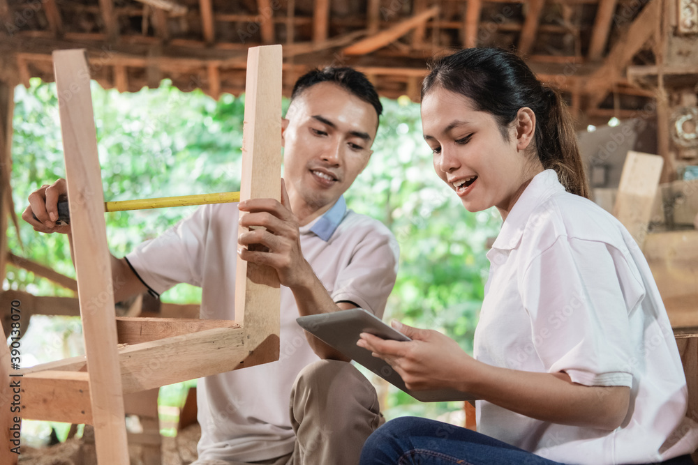 business women use a pad and carpenters measure wood to make crafts in workshops business women use a pad and carpenters measure wood to make crafts in workshops
