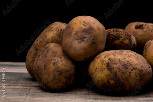 potatoes on a wooden floor  potatoes waiting to be peeled or washed