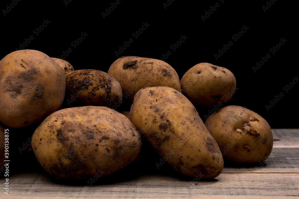 potatoes on a wooden floor, potatoes waiting to be peeled or washed potatoes on a wooden floor, potatoes waiting to be peeled or washed