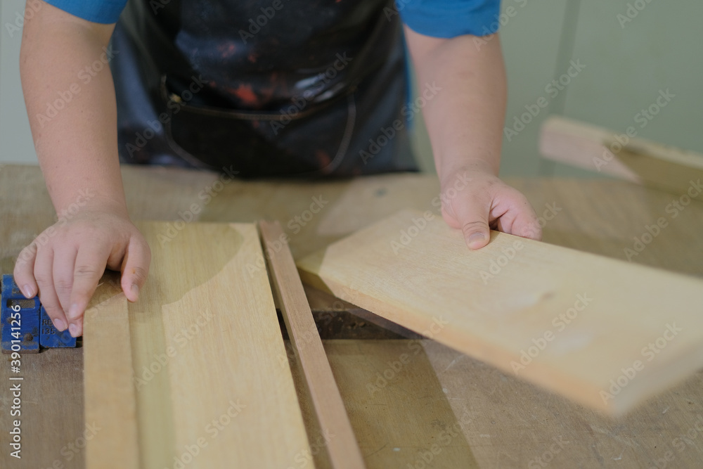 Carpenter joining pieces of wood with long bar clamp and glue. Carpenter joining pieces of wood with long bar clamp and glue.