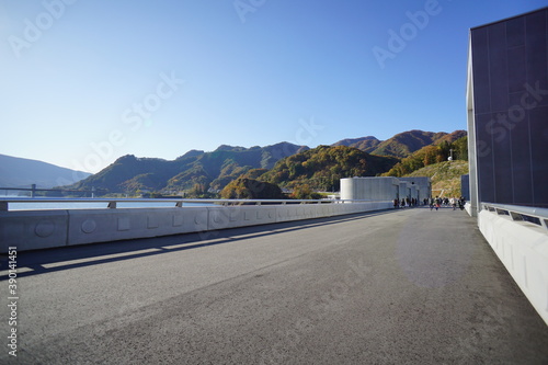 On the dam body. Blue sky and autumn mountains. Japanese landscape. Beautiful autumn landscape. © Hirotsugu