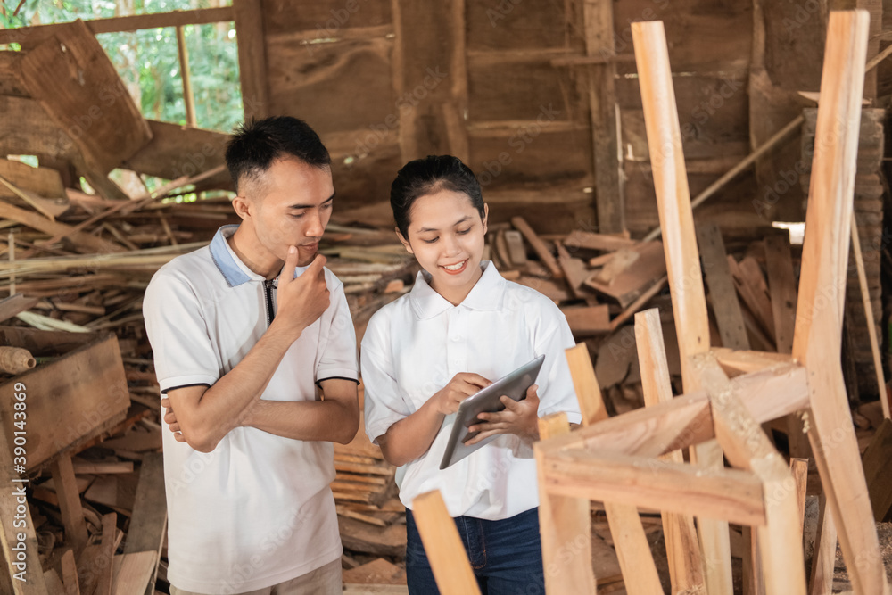 two young entrepreneurs use a tablet pc when looking at furniture design at the workshop two young entrepreneurs use a tablet pc when looking at furniture design at the workshop