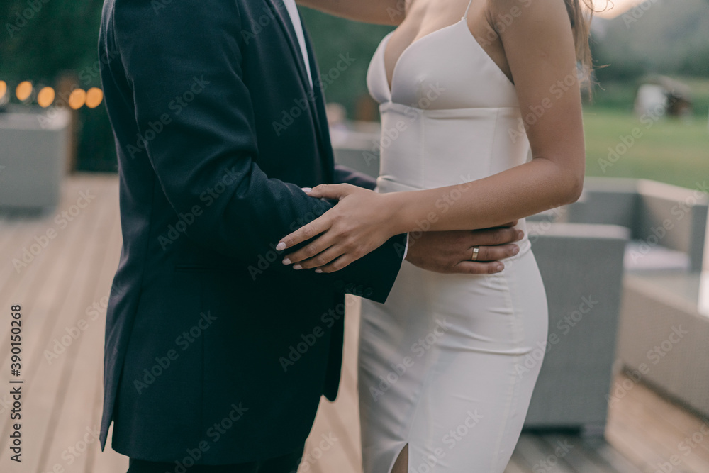 The groom in a suit hugs the bride in a wedding dress The groom in a suit hugs the bride in a wedding dress