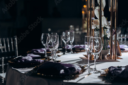 Solemn wedding table setting with glasses and candles in a restaurant