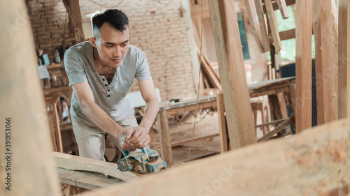 carpenters work using electric wood dowels while in a workshop