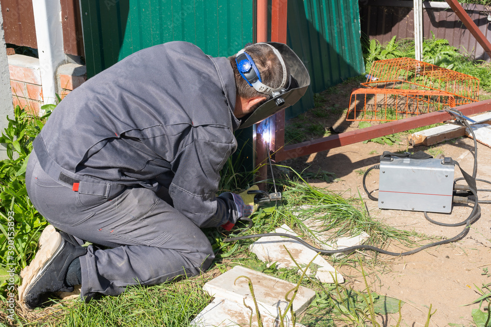 A man works with an inverter welding machine A man works with an inverter welding machine