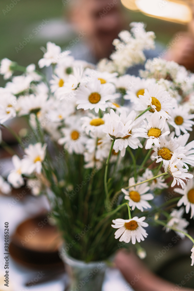 Obraz premium A bouquet of wild flowers in a vase on a table in the garden