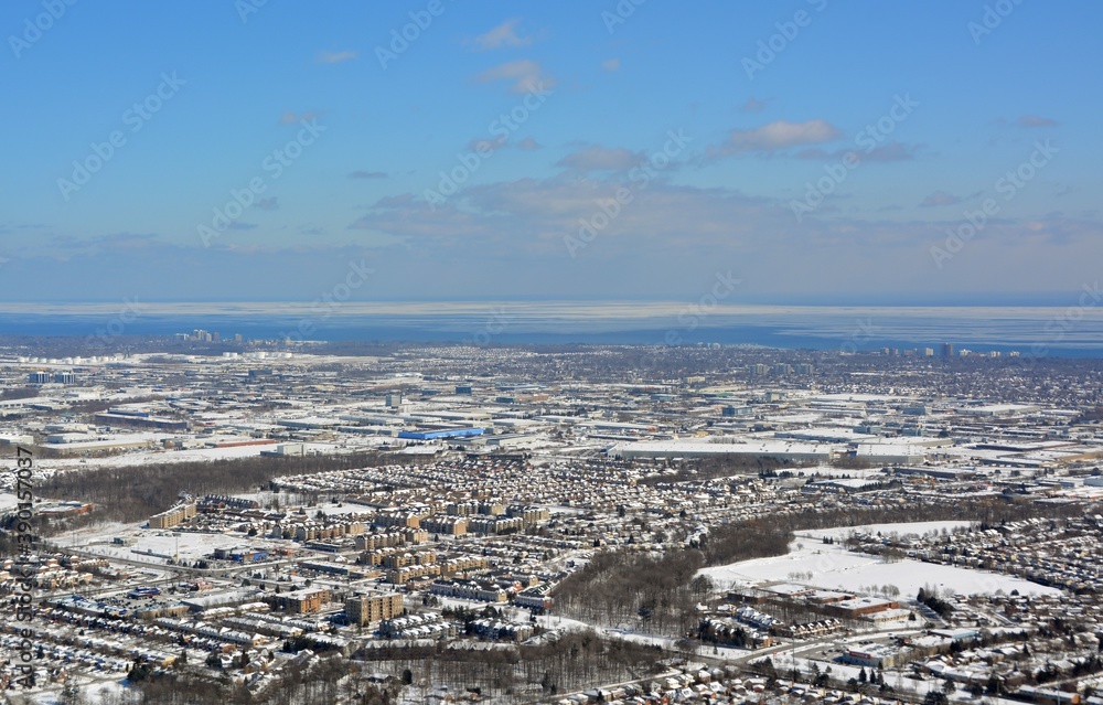 Aerial view across Burlington Ontario,  with Lake Ontario and Oakville in the far background, snow covered