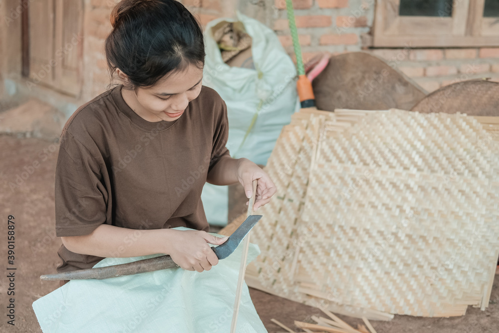 working women use knives to make bamboo mats at home working women use knives to make bamboo mats at home