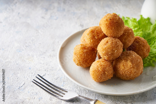 cheese balls, appetizer with herbs and sauces in a plate on a gray table