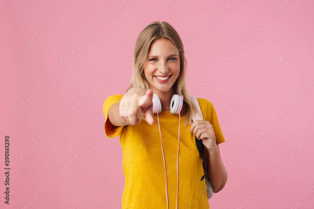 Cheerful beautiful girl smiling and pointing finger at camera Cheerful beautiful girl smiling and pointing finger at camera
