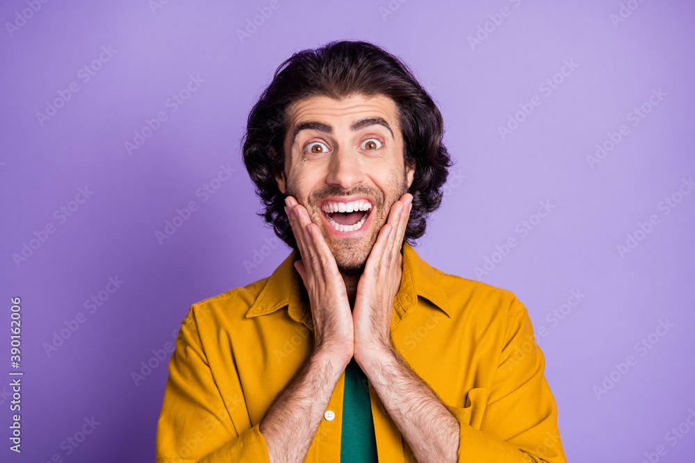 Portrait of young ecstatic amazed happy shocked man guy male scream hold hands on cheeks isolated on violet color background Portrait of young ecstatic amazed happy shocked man guy male scream hold hands on cheeks isolated on violet color background