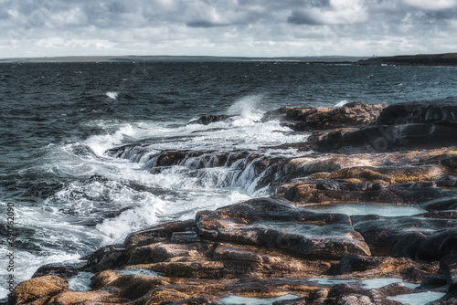 Waves of the Barents Sea on the bank of the Red Rocks on the Srednyi Peninsula. Russia, Murmansk region