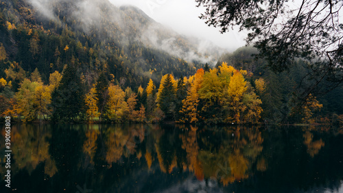 Alpine lake of Piburger See in the Otztal valley in the Austrian Tyrol during autumn, colorful trees in the Alps photo