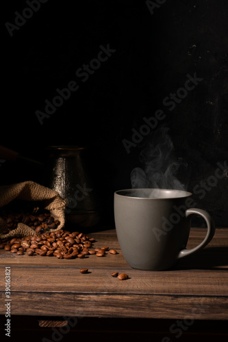 Cup of coffee and coffee beans on a wooden table